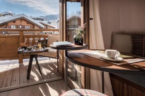 a balcony with a table with a cup of coffee at Coeur de Megève in Megève