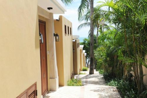 a walkway between two buildings with palm trees at Pawanthorn Samui - SHA Plus in Chaweng