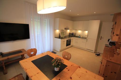 a living room with a wooden table and a kitchen at Villa Parasana in Gordevio
