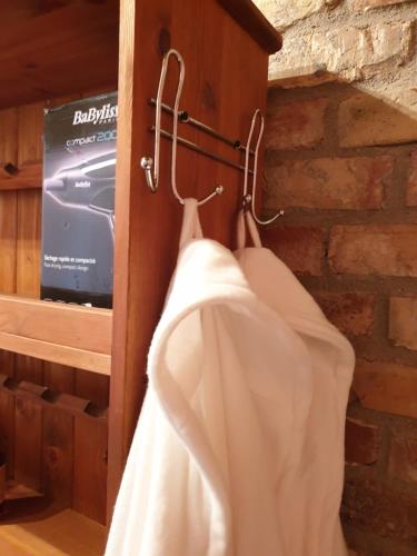 a white robe hanging on a wall with a tv at DOM GOŚCINNY PTASZARNIA - NATURA-Free PARKING in Świnoujście