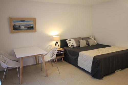 een slaapkamer met een bed, een bureau en een tafel bij Villa Parasana in Gordevio