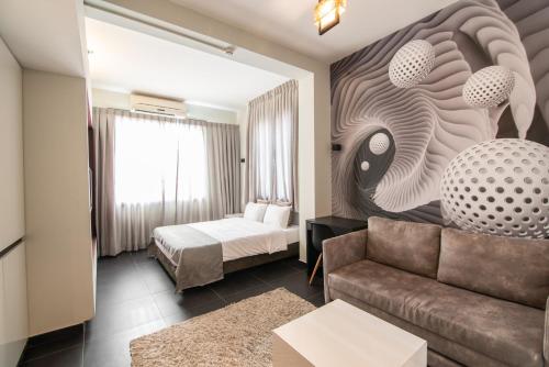 ein Hotelzimmer mit einem Sofa und einem Bett in der Unterkunft 27Montefiore - Urban ApartHotel TLV in Tel Aviv