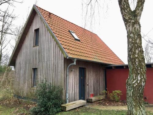 a barn with an orange roof and a tree at drunter-drueber-Maisonette-Ferienwohnung-Luebecker-Bucht in Scharbeutz