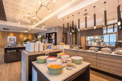 a restaurant with bowls of food on a counter at Belaire Suites Hotel in Durban