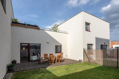 a white house with a deck with chairs on it at Apartment Aloha in Znojmo