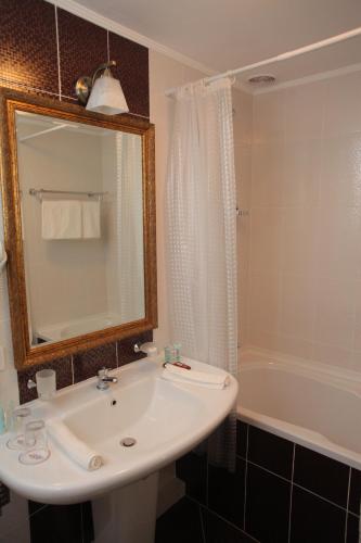 a bathroom with a sink and a bath tub at Fontush Boutique Hotel in Ivano-Frankivsʼk