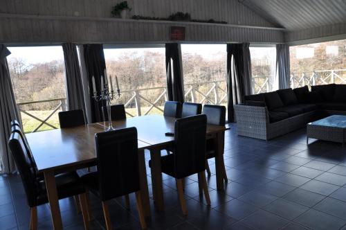 a dining room with a table and chairs and a couch at Hotel Bella Luna in Båstad