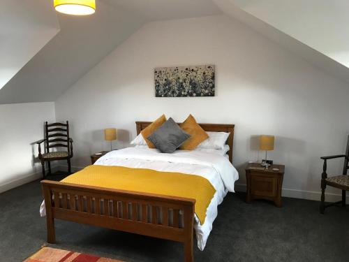 Salt Pot Cottage في سكيبتون: غرفة نوم بسرير كبير مع بطانية صفراء