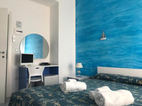 een slaapkamer met een bed en een bureau met een computer bij Divino Bed & Breackfast in Manfredonia