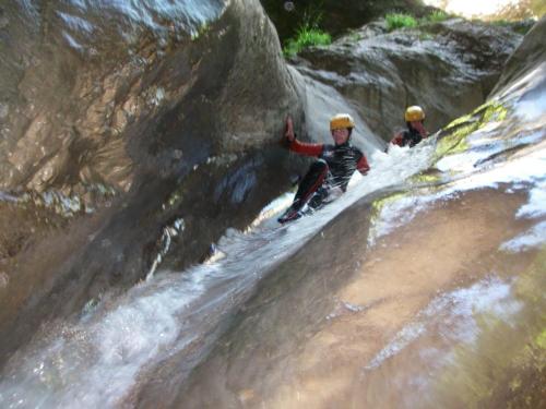 two people are climbing up a waterfall on a mountain at Hotel Rural Don Quijote in Cuenca
