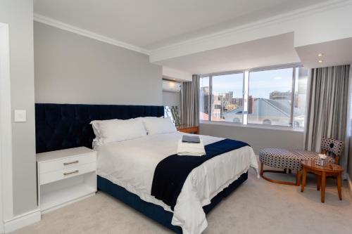 ein Schlafzimmer mit einem großen Bett und einem großen Fenster in der Unterkunft Devonshire 401 in Kapstadt