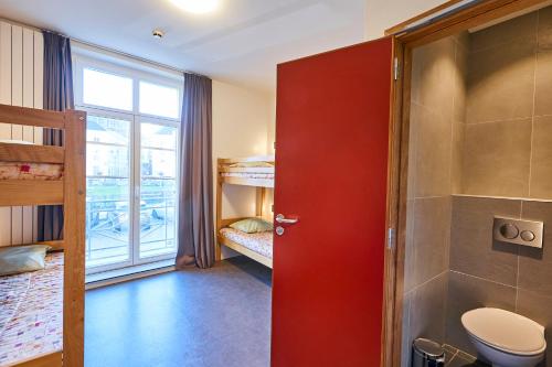 ブリュッセルにあるジャック ブレル ユース ホステルの赤いドアとトイレ付きのバスルーム