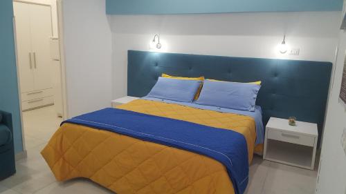 a bed with a blue headboard in a bedroom at B&B Villa Letizia in Castelbuono