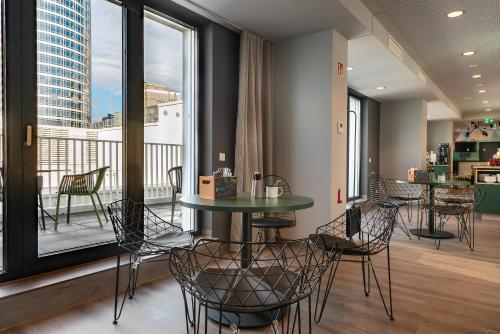 a room with a table and chairs and a balcony at the niu Charly in Frankfurt