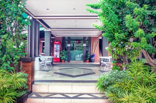 a lobby of a building with chairs and trees at Myvilla Langkawi Hotel in Pantai Cenang