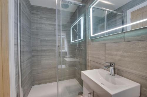 uma casa de banho com uma cabina de duche em vidro e um lavatório. em Hafan y Ddinas Cardiff Apartment 1 em Cardiff
