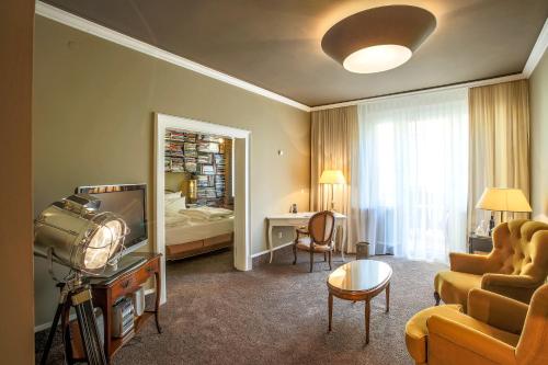 uma sala de estar com um sofá e uma televisão e um quarto em Posthotel Alexander Herrmann em Wirsberg