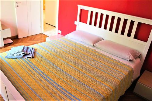 ミラノにあるYouhome Millelire Apartmentの赤い壁のベッドルーム1室(大型ベッド1台付)