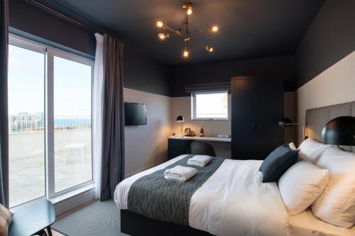 a bedroom with a large bed and a large window at The Barrister Hotel in Valletta