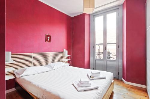Schlafzimmer mit einem großen Bett mit roten Wänden in der Unterkunft Buenos Aires Shopping Flat in Mailand