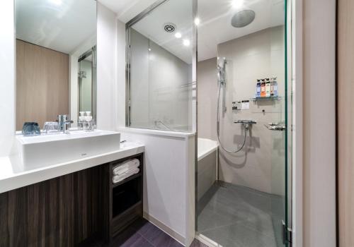 a bathroom with a sink and a shower at Daiwa Roynet Hotel Hiroshima-ekimae in Hiroshima