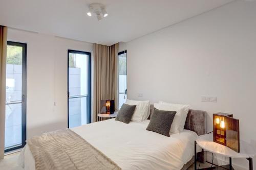 1 dormitorio con 1 cama blanca grande y ventanas en Luxury Graça Apartment The Most Amazing View of Lisbon en Lisboa