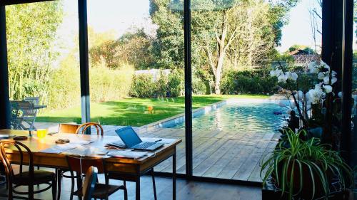 - une table avec un ordinateur portable à côté de la piscine dans l'établissement Oasis de Caudéran, à Bordeaux