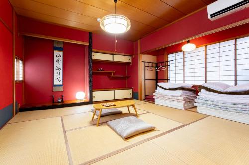una habitación con paredes rojas y una mesa en una habitación en Guesthouse Nagonde, en Kanazawa