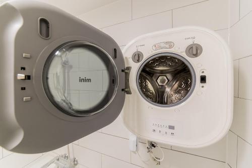 a washing machine with a mirror in a bathroom at Pyeongtaek Stay Tourist Hotel in Pyeongtaek