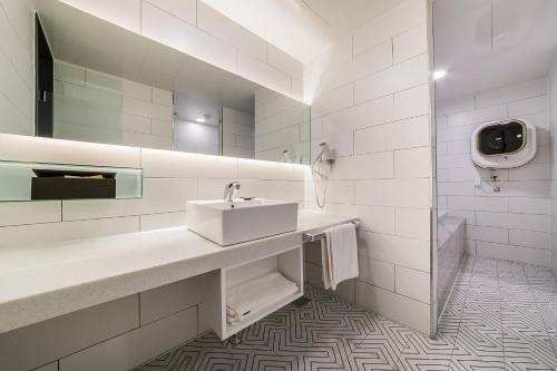 a white bathroom with a sink and a mirror at Pyeongtaek Stay Tourist Hotel in Pyeongtaek
