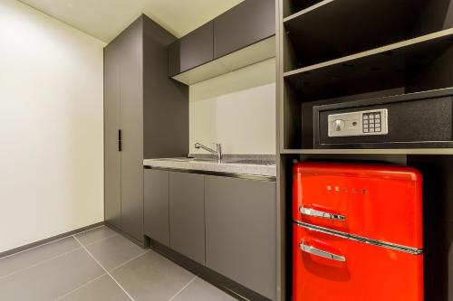 a red refrigerator in a kitchen with a sink at Pyeongtaek Stay Tourist Hotel in Pyeongtaek
