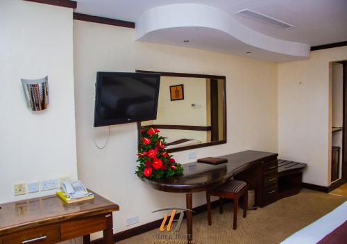 a room with a desk with a mirror and a television at Utalii Hotel in Nairobi
