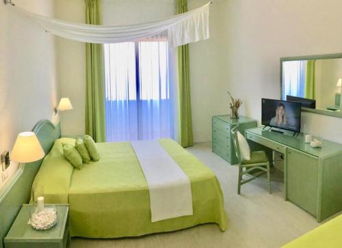 1 dormitorio con cama verde y escritorio con ordenador en Hotel Gargano, en Vieste