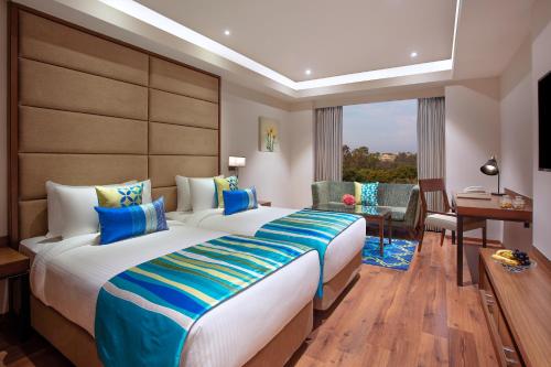 a hotel room with a large bed and a desk at Fortune Avenue, Jalandhar - Member ITC's Hotel Group in Jalandhar