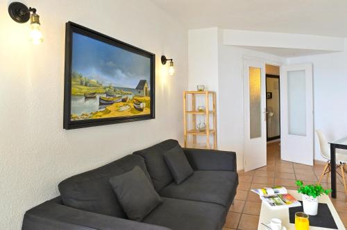 a living room with a couch and a painting on the wall at MyFlats Azul in El Campello