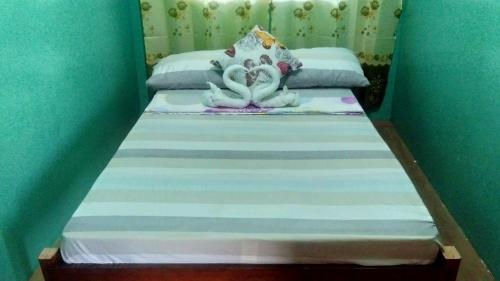 a bed with two swans on top of it at Acuario Beach Inn in San Vicente