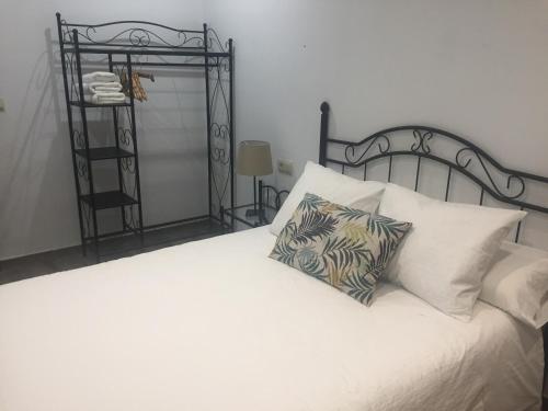 una camera da letto con letto bianco con testiera e cuscini neri di Apartamento Tolaitola a Toledo