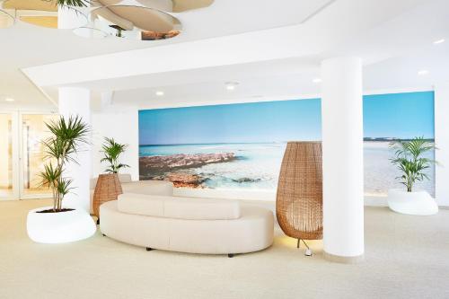a living room with a view of the ocean at Grupotel Tamariscos in Cala'n Bosch