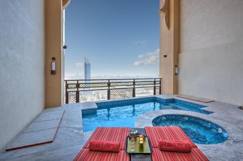 a swimming pool with a table and a balcony at Arjaan by Rotana - Dubai Media City in Dubai