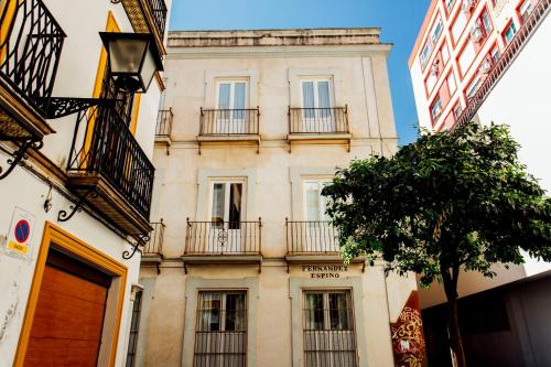 a tall building with balconies and a tree at Casa Patio del Siglo XIX in Seville