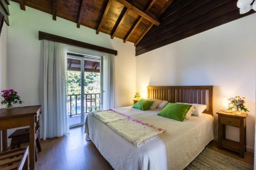 a bedroom with a large bed and a window at Quinta da Pousadela - Agroturismo in Amarante