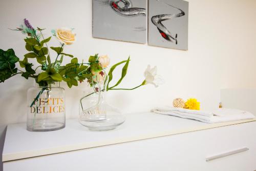 a white shelf with two vases and flowers on it at InnPisaRentals 2 - Airstation Central Flat in Pisa