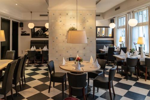 a restaurant with tables and chairs and a checkerboard floor at Hotel Werk II in Bocholt