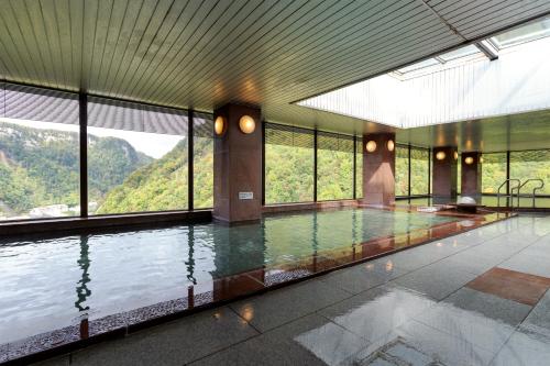 a swimming pool with a view of a mountain at Choyo Tei in Kamikawa
