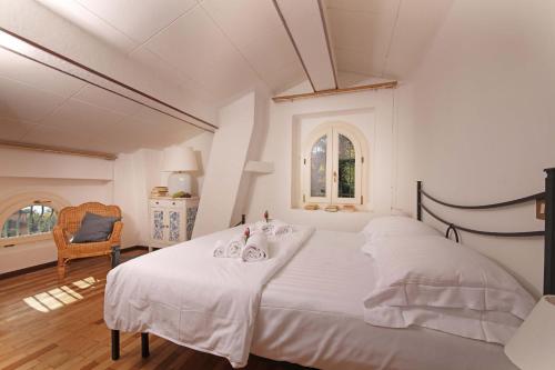 サロにあるVilla FiordiSoleの白いベッドルーム(大きな白いベッド1台、椅子付)