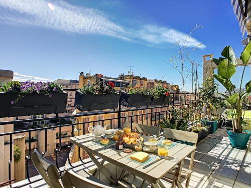 a table on a balcony with a view of a city at Nestor&Jeeves - TOUCAN DUPLEX TERRACE - Hyper center - Top floor in Nice