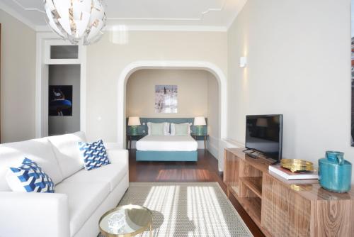 a living room with a white couch and a bed at YOUROPO - Market in Porto