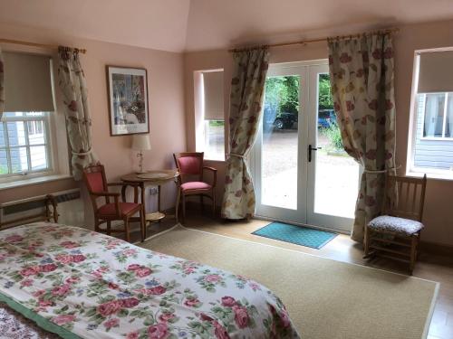1 dormitorio con 1 cama y puerta corredera de cristal en Luffness Castle Cottage, en Aberlady