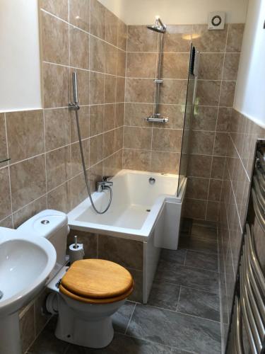 a bathroom with a tub and a toilet and a sink at Luffness Castle Cottage in Aberlady