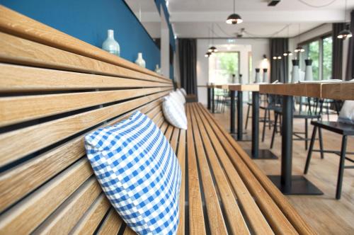 a wooden bench with a vase sitting on it at Lieblingsplatz Strandhotel in Sankt Peter-Ording